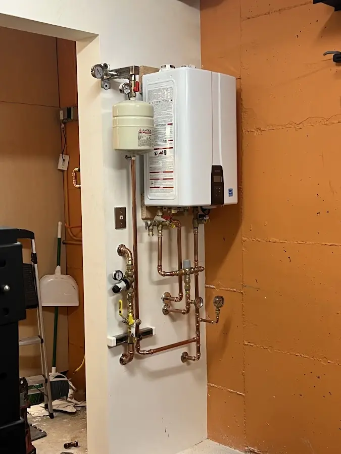 Plumbing technician inspecting water heater connections in Havelock